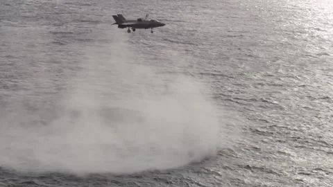 F-35B Lightning II creating jet wash hovering over sea Stock Footage 259036012