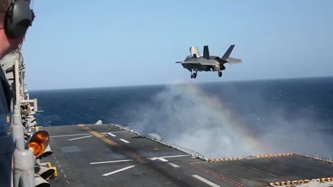 F-35B Lightning II hovering above USS Makin Island for vertical landing Stockbeeldmateriaal 150355716