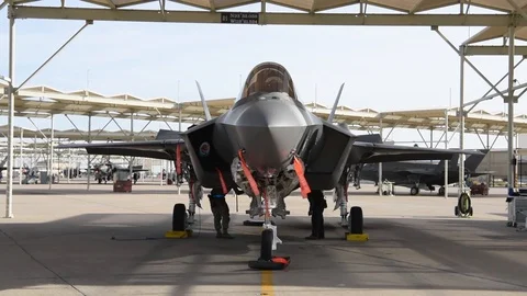 F-35C Lightning II parked beneath hangar with remove before flight tags Stock Footage 103259064