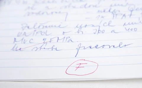 F grade from the test written red on netebook paper. Stock Photos