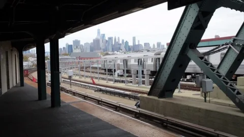 F subway train pulls into Smith and 9th street station overlooking Manhattan Stock Footage 98632837