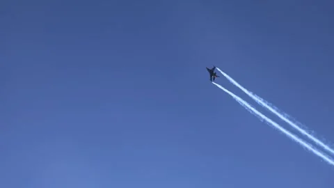 The F16 fighter performs aerobatics over the sea against the background of Stockbeeldmateriaal 308151804