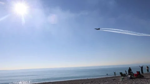 The F16 fighter performs aerobatics over the sea against the background of Stockbeeldmateriaal 308152570