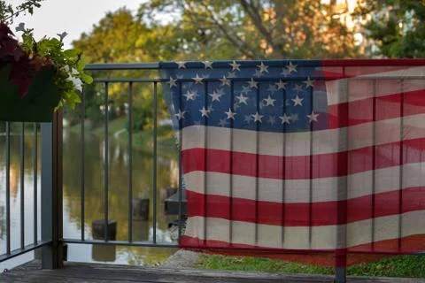 Fabric with American flag print hanging on the railing on the river embankment Stock Photos