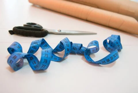 Fabric and objects for sewing clothes. Roulette and patterns on the table Stock Photos