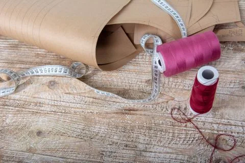 Fabric and objects for sewing clothes. Roulette, coil, and patterns on the ta Stock Photos