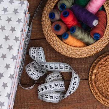 Fabric and objects for sewing. Cotton fabric is stacked. A centimeter tape Stock Photos
