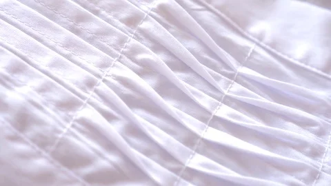 Fabric as background. 4k, slow motion, white pleated fabric Видео 81727900