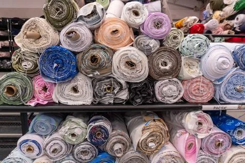 Fabric bolts displaying various patterns in a retail store Stock Photos