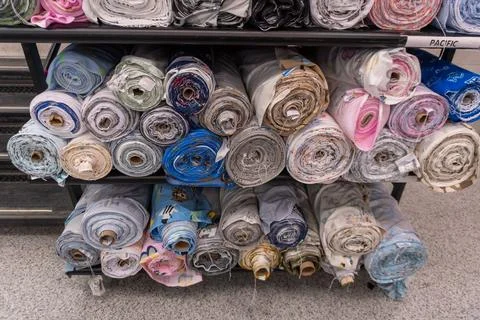 Fabric bolts displaying various patterns in a retail store Stock Photos
