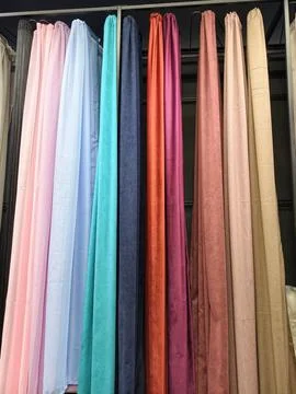 Fabric curtains in multiple designs and colors displayed on racks Stockfoto's