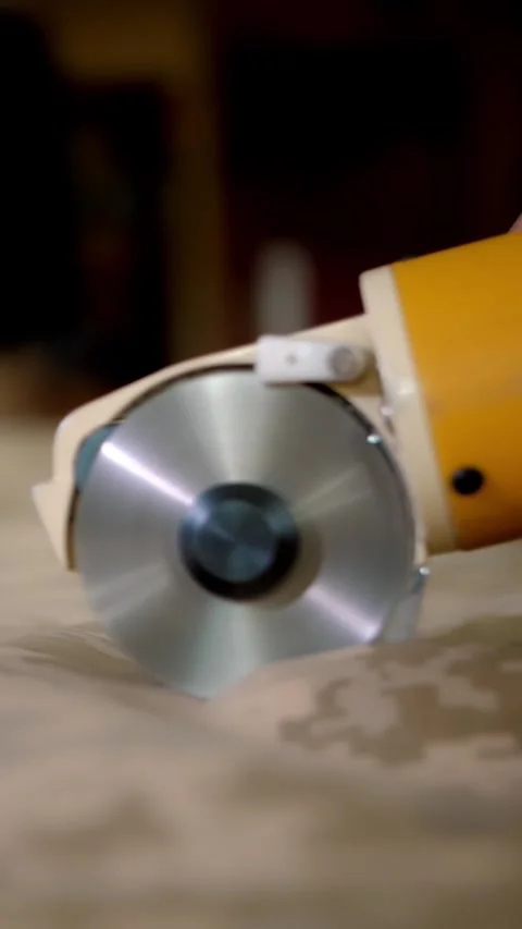Fabric cutter. close-up. the tailor cuts fabric with electric cloth cutter on Stock Footage 316782308