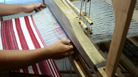 Fabric making loom close-up. a man makes fabric on a satre wooden loom slow mo Stock Footage 157380397
