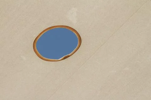Fabric pattern cover rooftop with blue sky revealed through a round hole Stock Photos