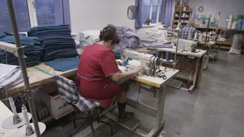 Fabric production worker at her workplace, working with a sewing machine Video stock 150657801