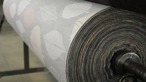 Fabric roll on unwinding machine close-up at factory. Measuring length of fabric Stock Footage 274253147