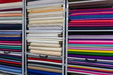 Fabric rolls creating colorful texture in textile store Stock Photos