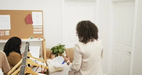 Fabric samples arriving in box and unfolding on desk with design sketches Stock Footage 334841160
