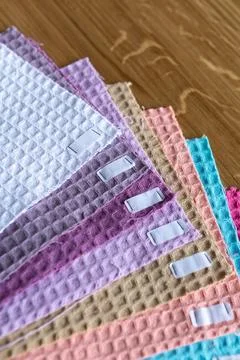Fabric samples in different colors are arranged neatly on a wooden surface .. Stock Photos