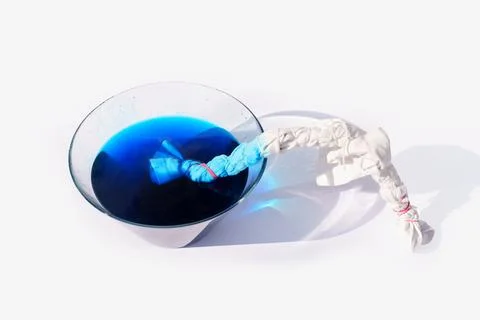 Fabric tie dyeing process with white cotton cloth and blue liquid dye 스톡 사진