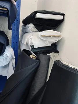 Fabrics textile roller stack on the rack inside the factory tailor Stock Photos