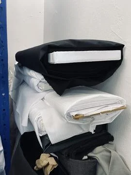 Fabrics textile roller stack on the rack inside the factory tailor Stock Photos