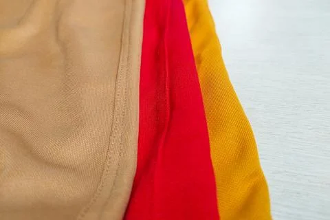 Fabrics in various bright colors such as yellow, red, and cream. Stock Photos