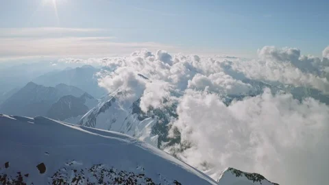 Fabulous light clouds float under snow summit, climbers conquer mountain top Stock Footage 126365051