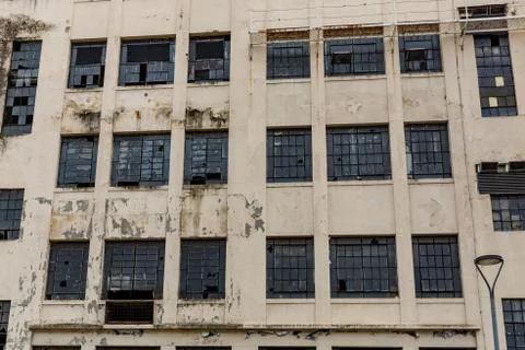 The facade of an abandoned building. Broken windows and peeling paint. Stock Photos