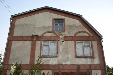 Facade of an abandoned building on which plaster has fallen off Stock Photos