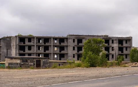 Facade of abandoned grey multi-storey soviet panel building Stock Photos