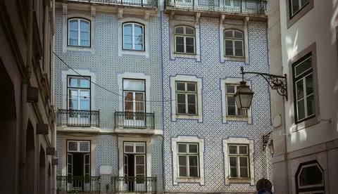 Facade of an ancient building covered with ceramic tiles typical for Portugue Stock Photos
