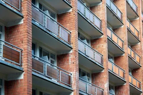 The facade of a brick building with several rows of balconies or loggias. 스톡 사진