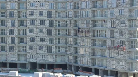 Facade of building with construction workers time-lapse Stock Footage 148130244