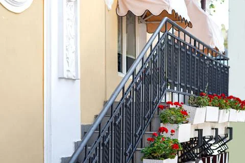 Facade of building with an external staircase with black railing. Stock Photos