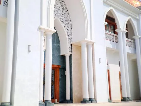 Facade of a building featuring white arches, columns, and intricate geometr.. Stock Photos
