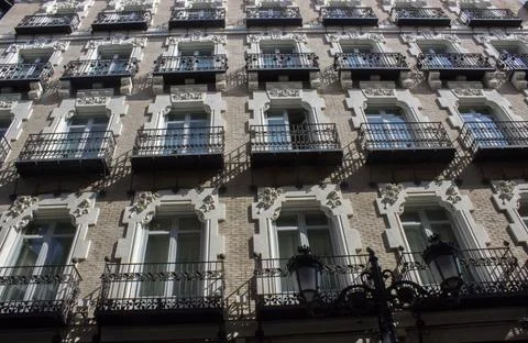 The facade of a building with many windows and wrought-iron balconies Foto stock