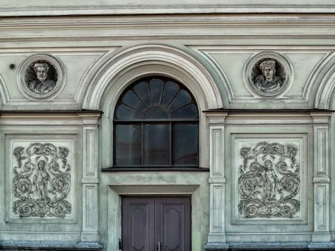 The facade of the building with two bas-reliefs, a sculptural panel, a door a Stock Photos