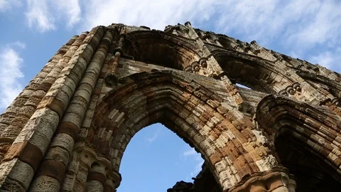 Facade Of Dramatic Old Ruined English Abbey Low Angle Against Blue Sky Track Video stock 125190975