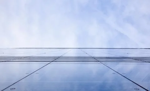 Facade of glass reflecting clouds Stock Photos