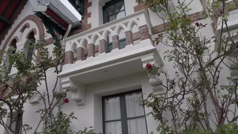 Facade historical white villa with rose frame. Panning 4K Stock Footage 258337538