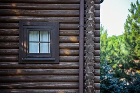 Facade of a log house with a square window. Fotos Stock