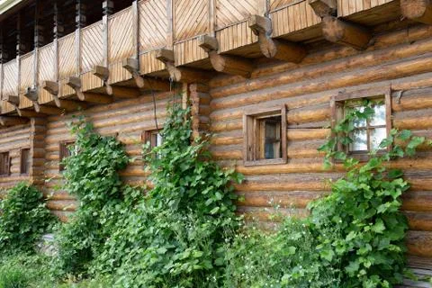 Facade of a log wall with windows. Russian architecture Stock Photos