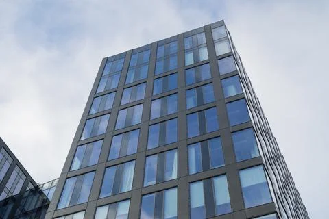 Facade of modern architecture building with windows with sky reflection Stock Photos