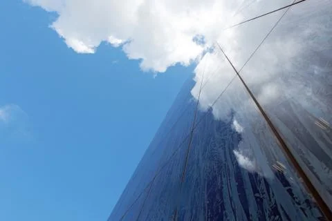 Facade of modern building with reflecting clouds Stock Photos