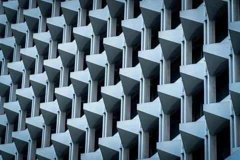 The facade of a modern building is a repeating geometric pattern. Stock Photos