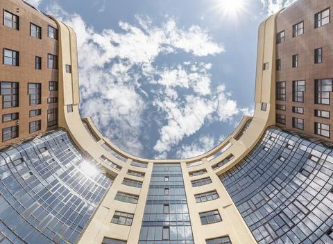 Facade of modern multi-storey brown beige building in the city. Bottom view Stock Photos