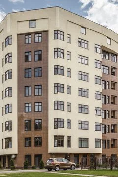 Facade of modern multi-storey brown beige building in the city. Space for text Stock Photos
