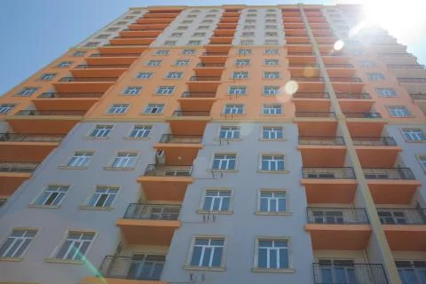 Facade of modern multi-storey new residential orange building near BAku . New Stock Photos