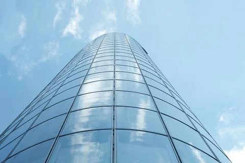 Facade of modern skyscraper with reflection of cloudy sky, low angle shot, Stock Photos